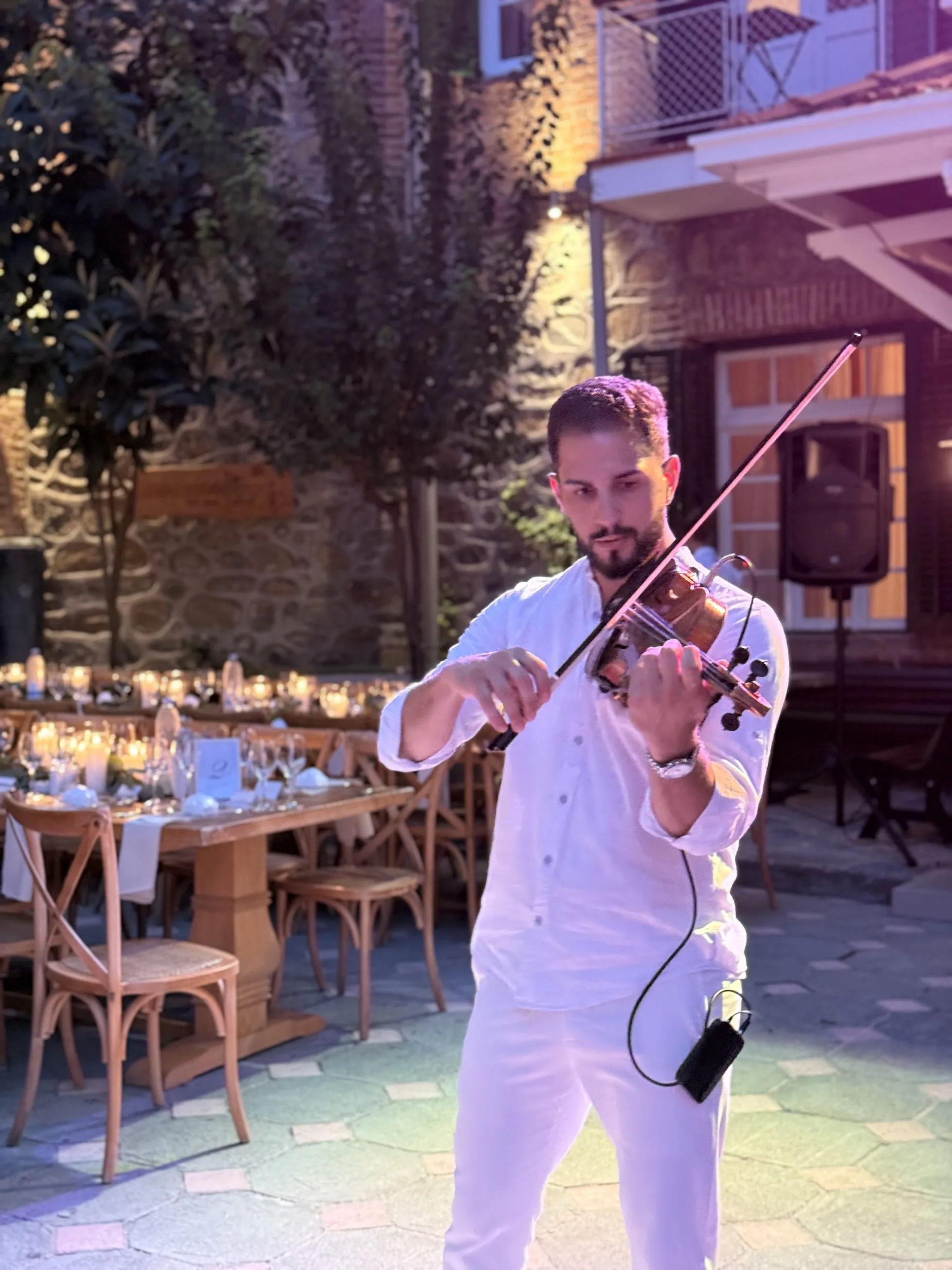 Marios playing violin in an evening courtyard